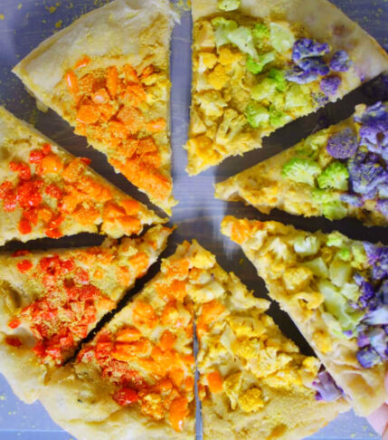 Rainbow Vegan Hummus Pizza grabbing a slice