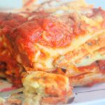 Slice of kid-friendly vegan vegetable lasagna showing layered noodles, vegetables, and dairy-free cheese