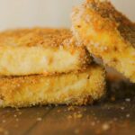 Breaded vegan turkey cutlets made from tofu stacked with crumbs around them.