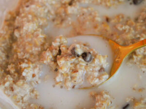 vegan cookie dough overnight oats with milk and chocolate chips on spoon