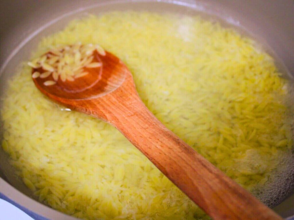 orzo cooking in a pan for homemade rice a roni copycat recipe
