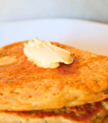 Close-up of golden vegan chia seed pancakes with butter and maple syrup
