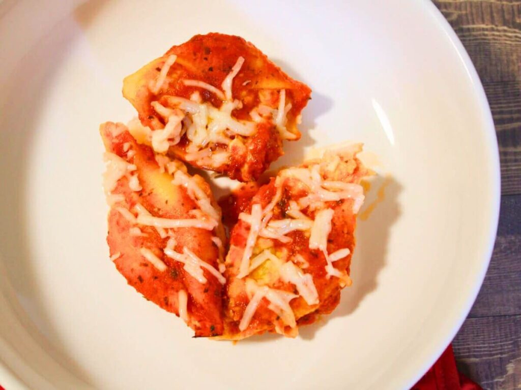 Overhead view of three vegan ricotta jumbo stuffed shells on a plate with marinara