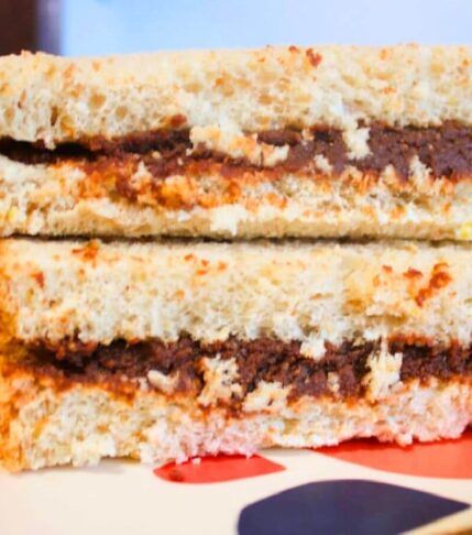 Chocolate sunflower seed butter spread thick on soft sandwich bread for a nut-free school lunch.