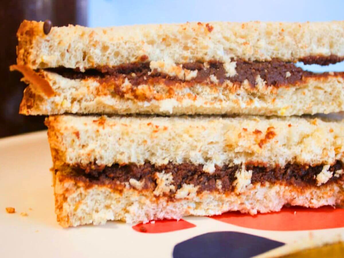 Chocolate sunflower seed butter spread thick on soft sandwich bread for a nut-free school lunch.