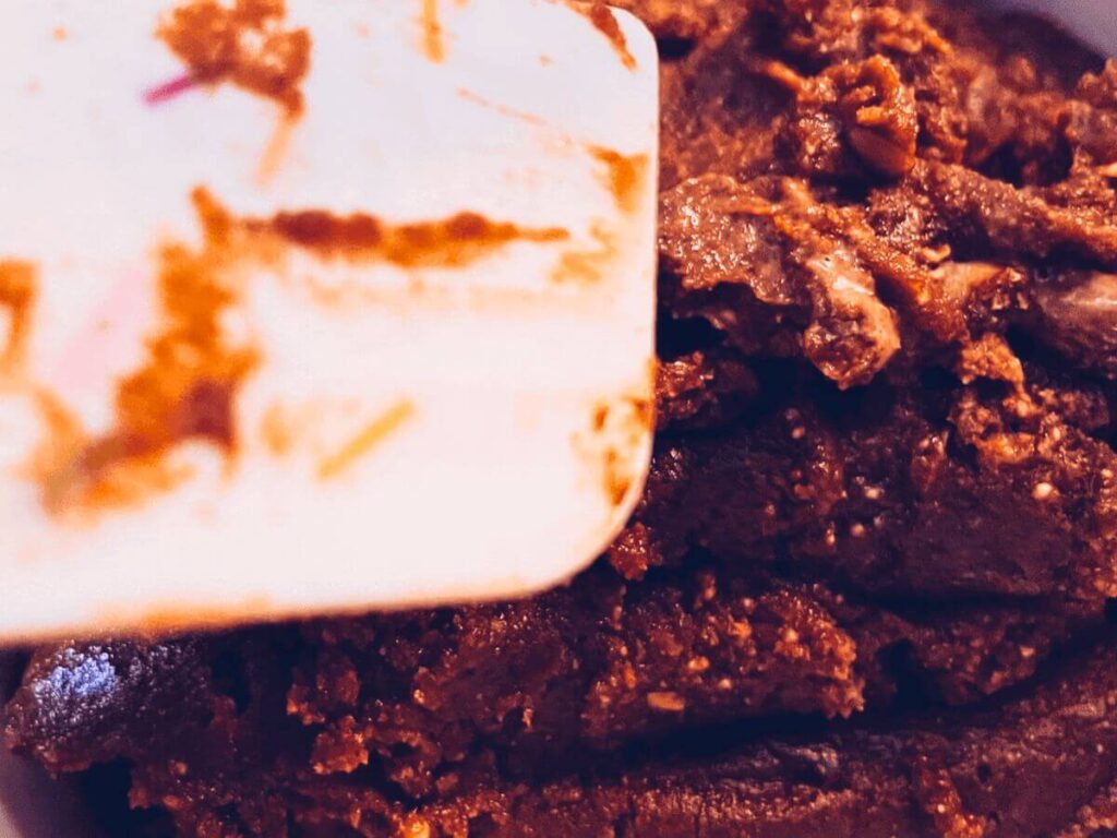 Thick and creamy chocolate sunflower seed butter scooped onto a spatula.