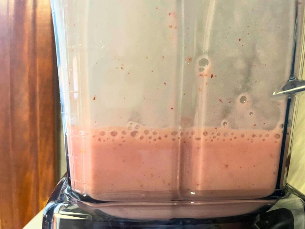 strawberry milk blending in a blender for vegan pancakes