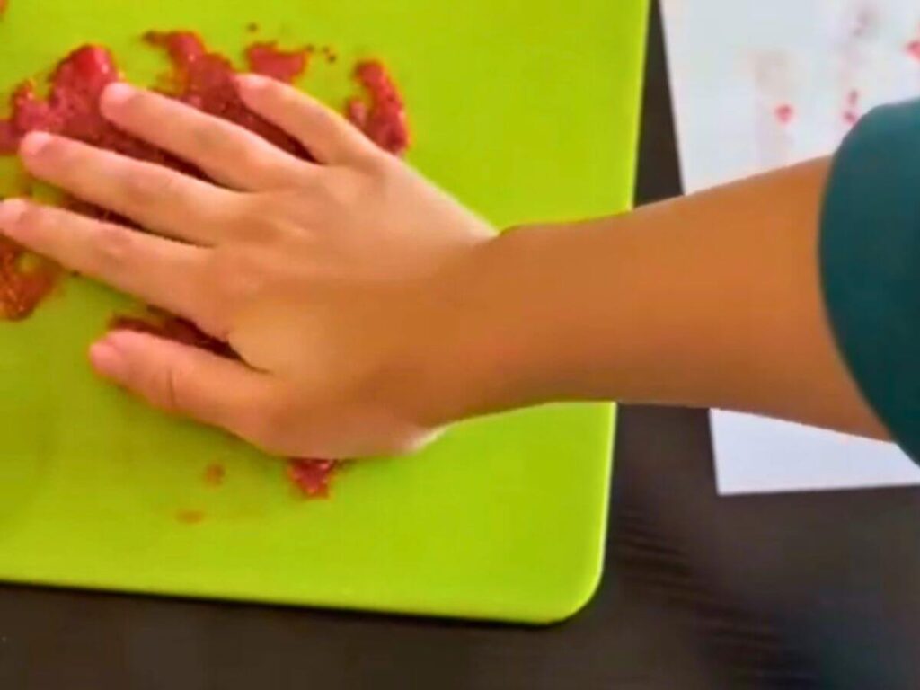 child hand touching homemade strawberry jam during messy kitchen play