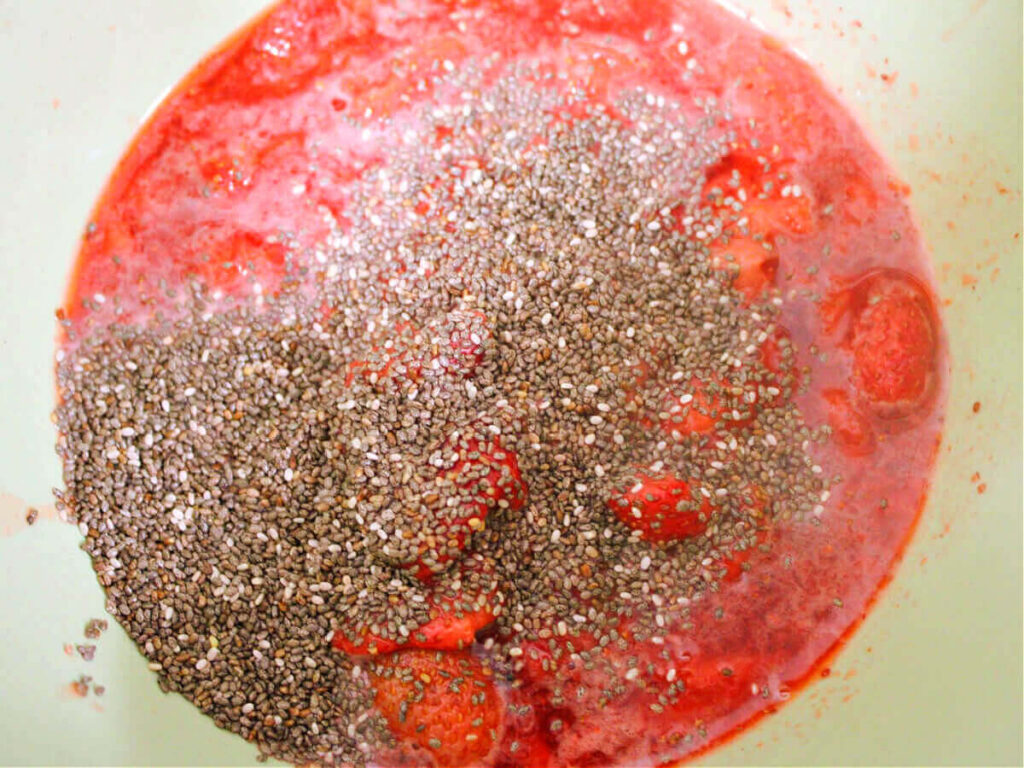 mashed strawberries and chia seeds in pan for sugar-free strawberry jam