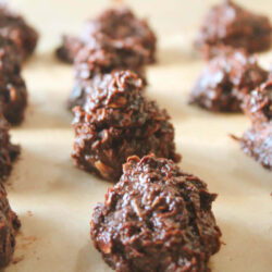 No-Bake Vegan Chocolate Goodies rolled into round balls on a lined cookie sheet