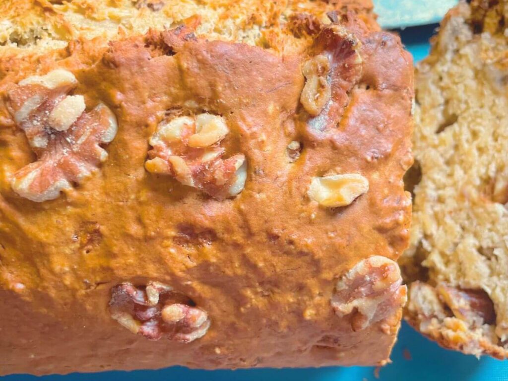 Overhead view of golden vegan banana bread with walnuts on top