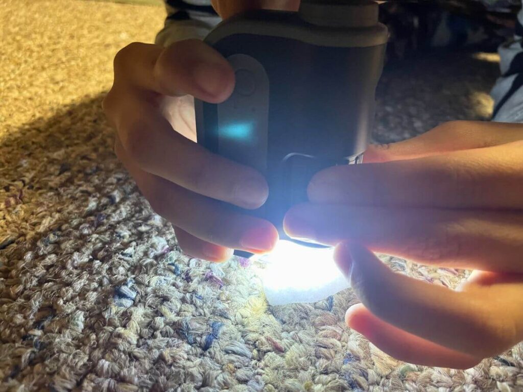 Child using handheld microscope to examine snow outdoors