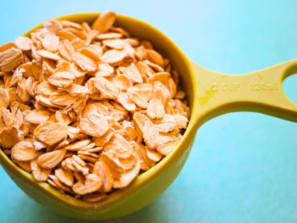 Half cup of rolled oats in a green measuring cup