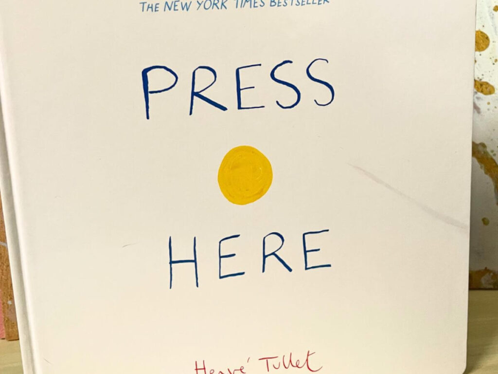 Cover of Press Here by Hervé Tullet featured in the Messy Little Readers Library paired with a healthy vegan pizza dough kids recipe