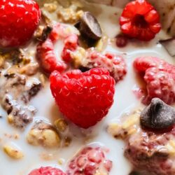 Finished vanilla overnight oats topped with fresh raspberries and chocolate chips for a simple, kid-friendly make-ahead breakfast option