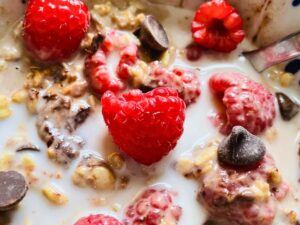 Finished vanilla overnight oats topped with fresh raspberries and chocolate chips for a simple, kid-friendly make-ahead breakfast option