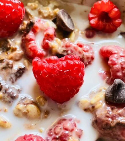Finished vanilla overnight oats topped with fresh raspberries and chocolate chips for a simple, kid-friendly make-ahead breakfast option