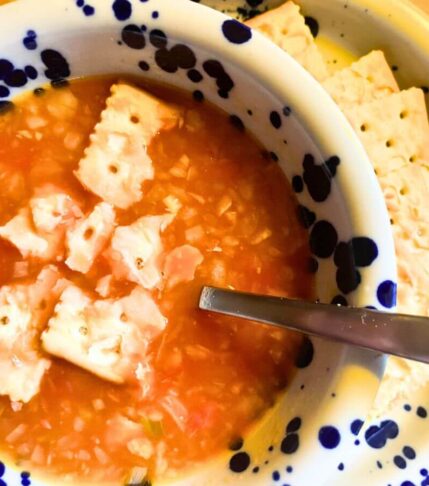 vegan tomato rice soup with rice and saltine crackers in bowl