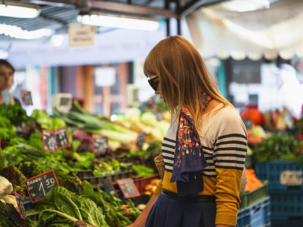 Person shopping for fresh vegetables at a farmers market representing real whole foods
