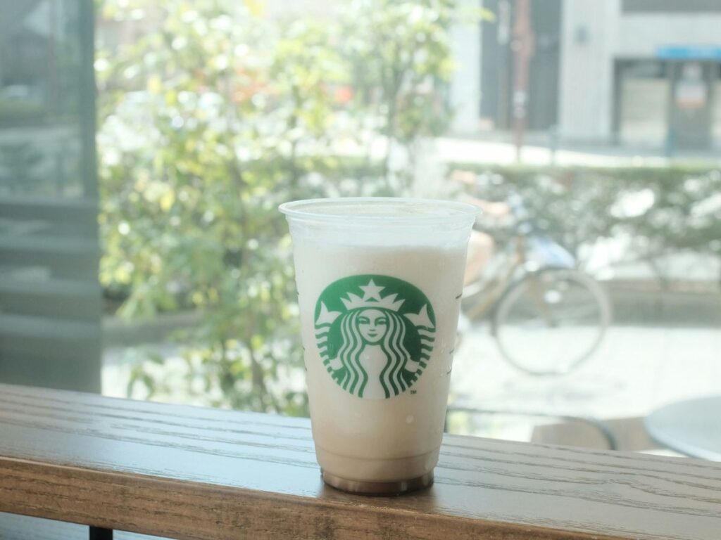 Close-up of a vanilla frappuccino with condensation forming and dripping down the cup as it slowly melts.