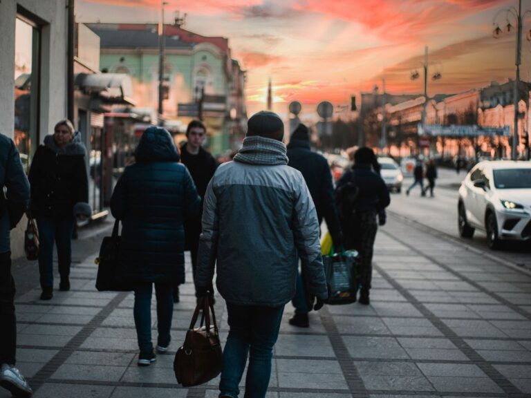 Everyday shoppers walking through a city as rising prices reshape where people buy food